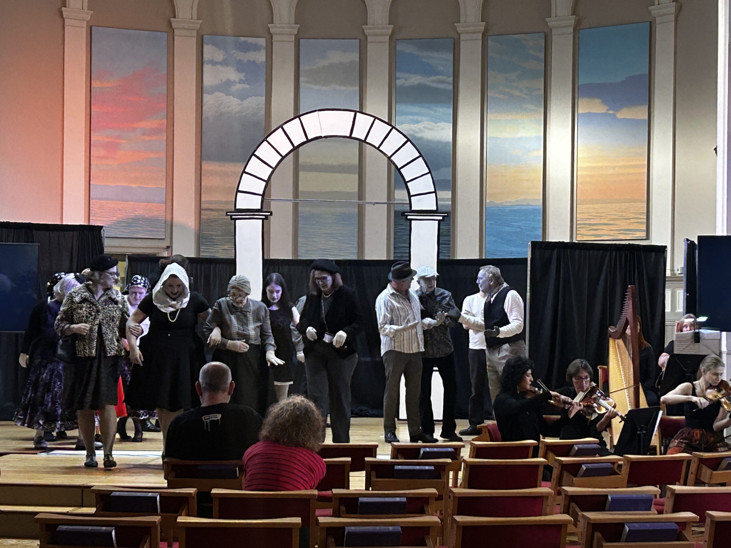 Aria Alba rehearse in black and white movie makeup at Stockbridge Parish Church. there are Black backdrops and a white Archway in the background.